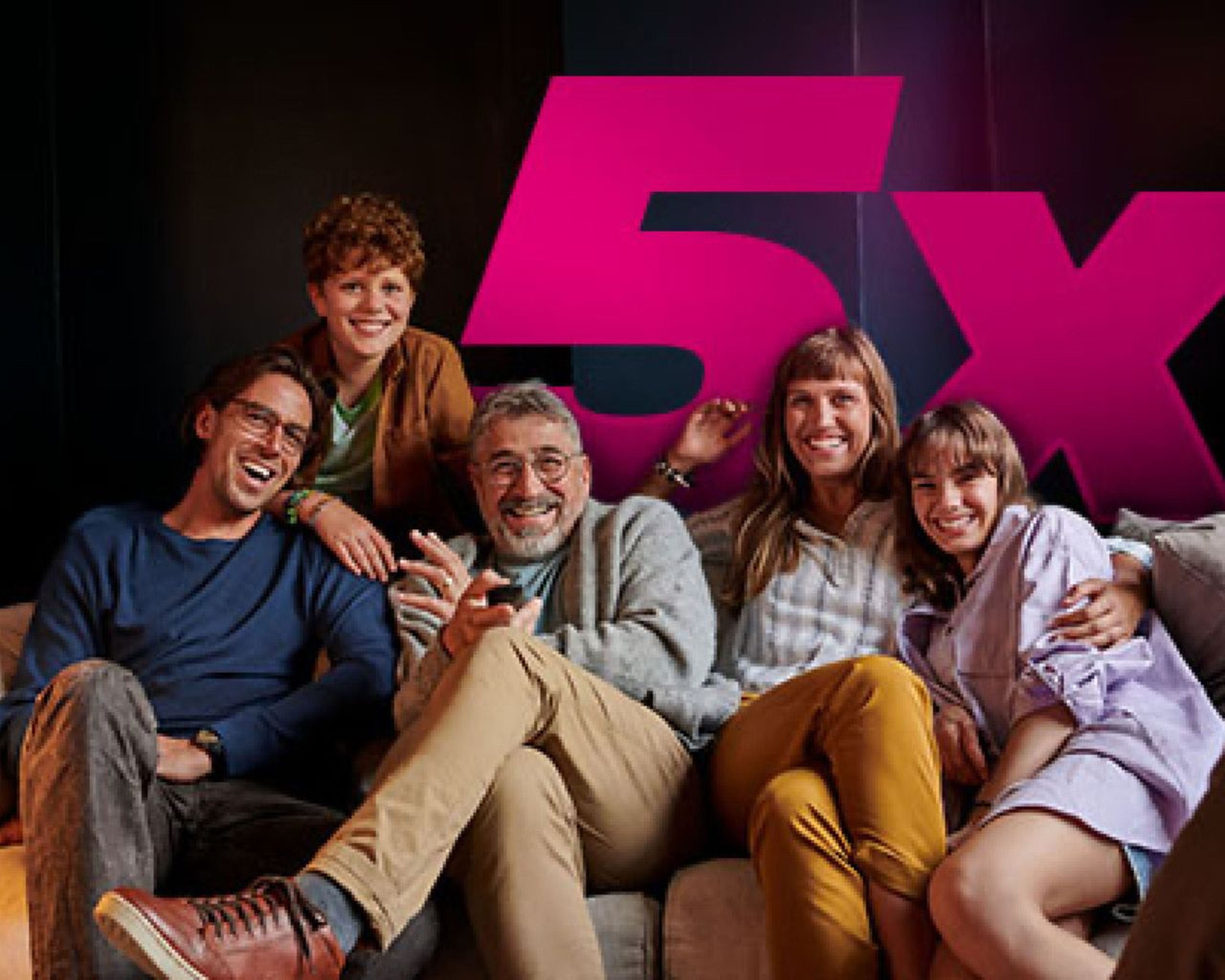 Skupina piatich usmievavých ľudí sedí na gauči s veľkým ružovým „5x“ v pozadí.