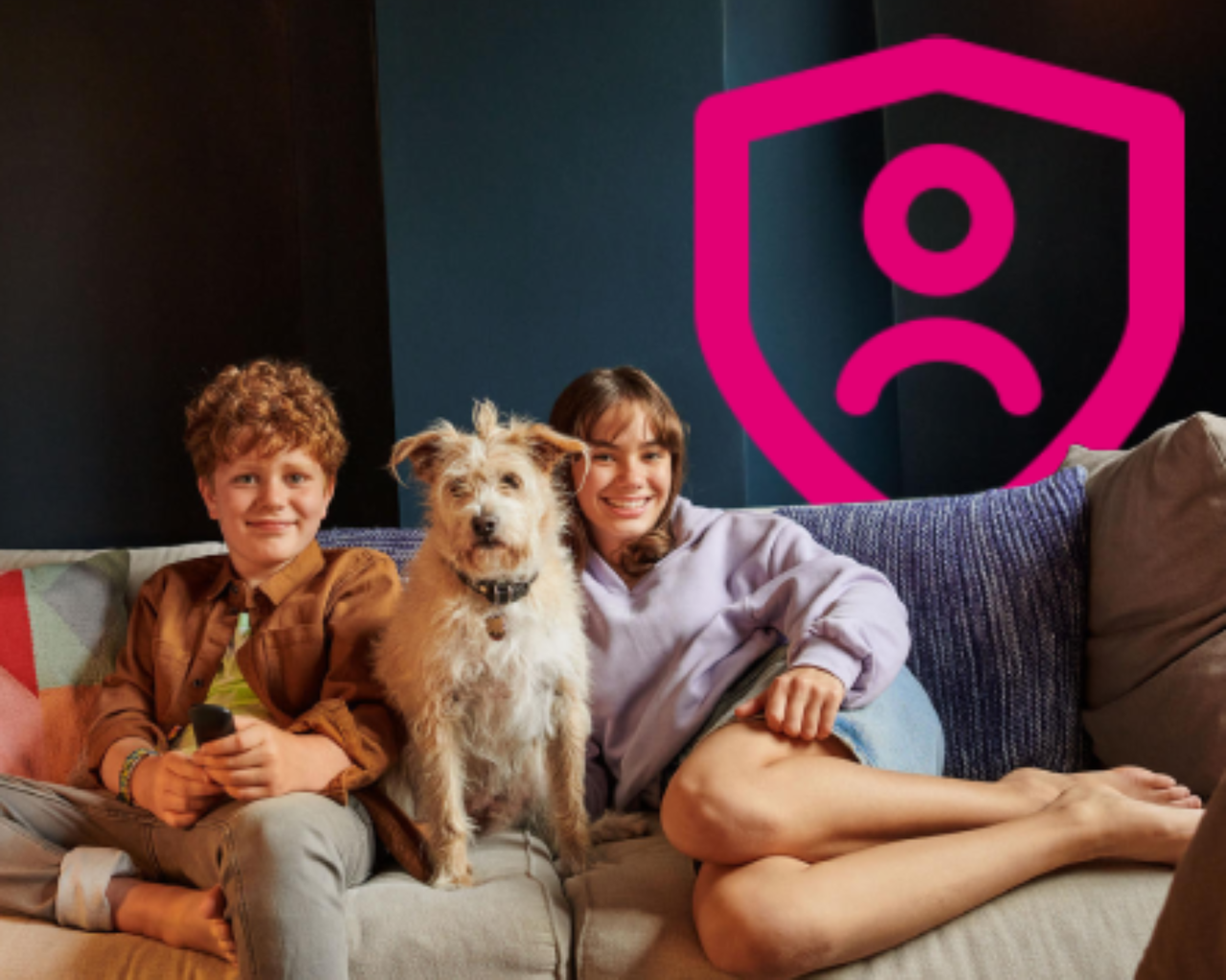 Deti a pes sedia na gauči pri ikonke ochrany v ružovej farbe.