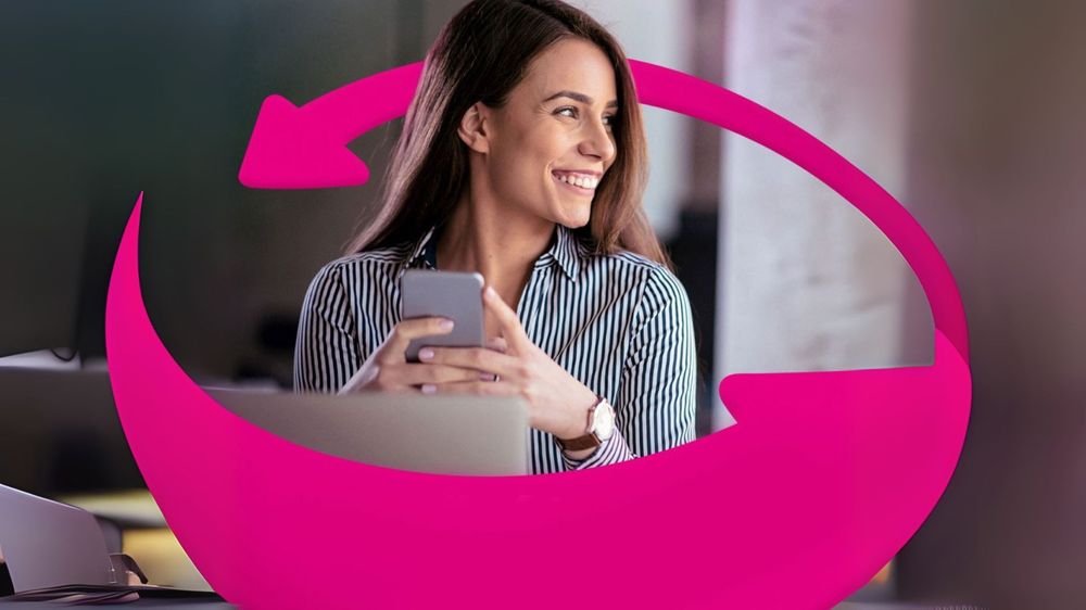 Usmievavá žena v pruhovanom tričku drží smartfón a sedí za stolom s notebookom. Okolo nej sú ružové šípky, ktoré naznačujú pohyb alebo zmenu.