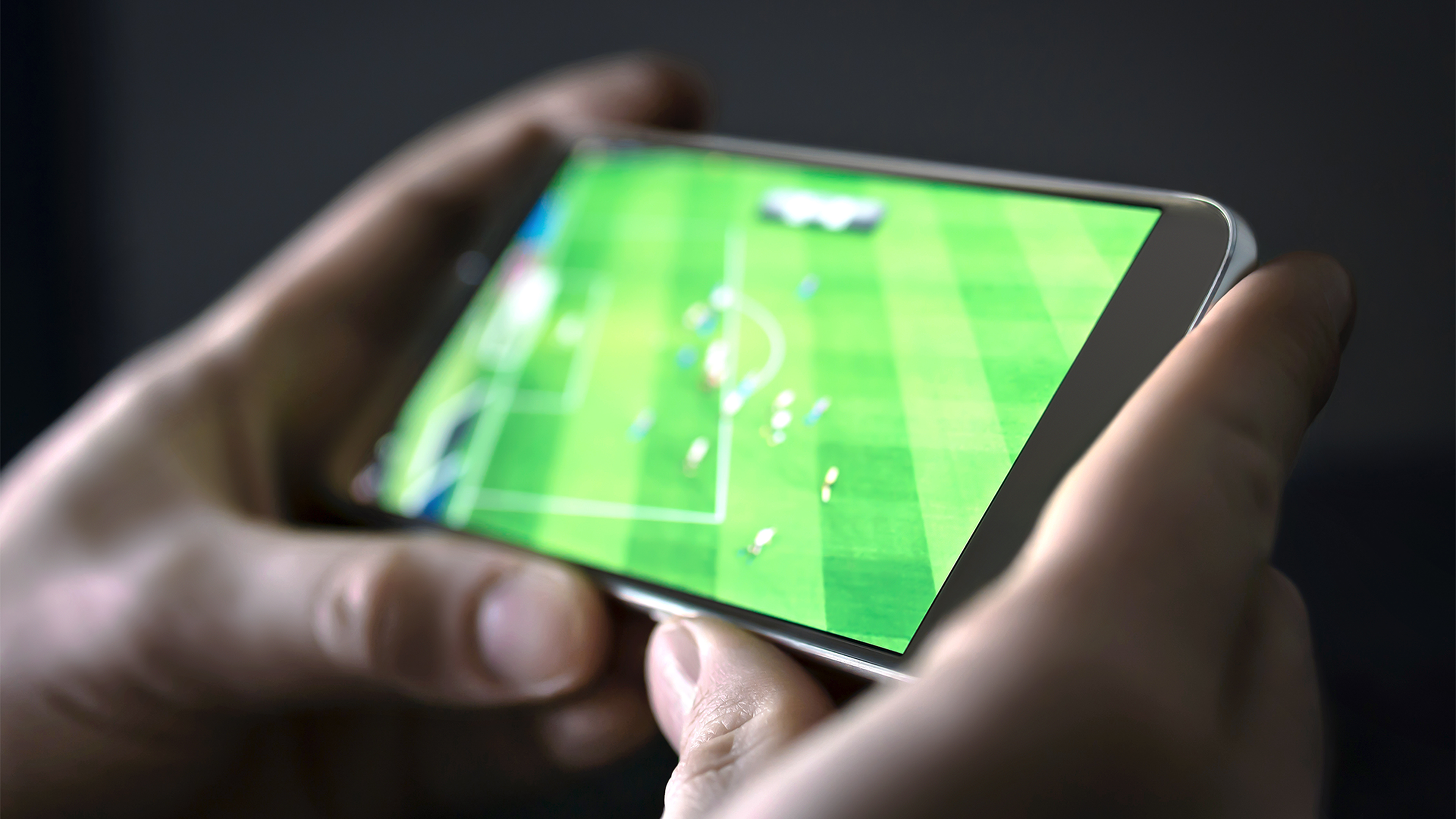 Osoba sledujúca futbalový zápas na mobile.