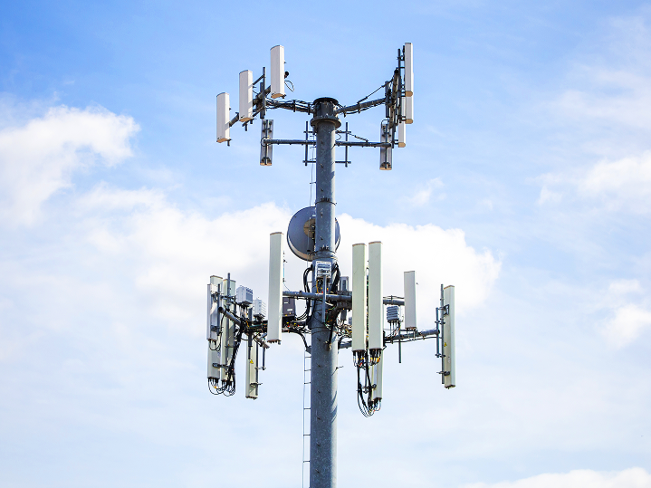 Vysielač privátnej 5G siete proti modrej oblohe - technologické riešenie pre bezpečný a rýchly priemyselný internet vecí (IoT).
