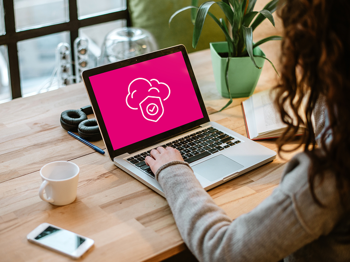 Žena pracuje na notebooku s ikonou cloudového úložiska a zámku - vizuálne znázorňuje bezpečné zálohovanie dát v Telekom Cloud službe s ochranou proti vymazaniu.
