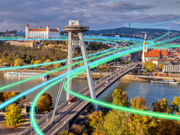 Pohľad na Bratislavský hrad, UFO a most SNP s digitálnymi svetelnými líniami symbolizujúcimi dátové pripojenie – IT:Works od T Business ako riešenie IT služieb a bezpečnosti pre firmy.