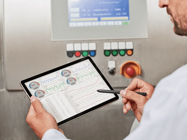 Technik pracuje s tabletom zobrazujúcim prevádzkové dáta a grafy zo zariadení – vizuál služby IoT Platforma od Telekomu